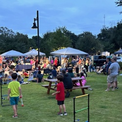 Kids playing, market booths, people milling about